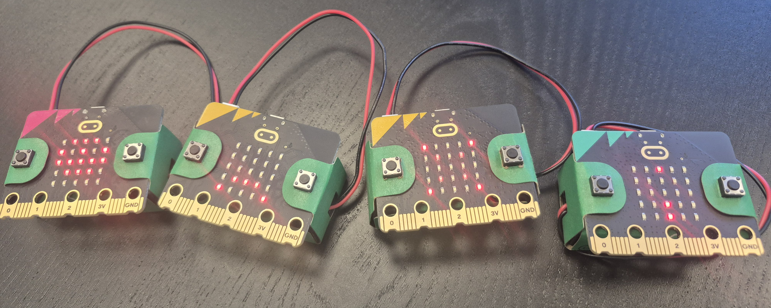 4 Microbits liegen auf einem Tisch