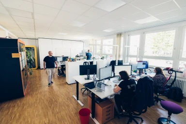 Open-plan office with employees at punkt.de, LLC
