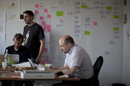 Wir entwicklen mit Scrum. Ein Team aus drei Kollegen arbeitet an einer effizienteren Entwicklung
