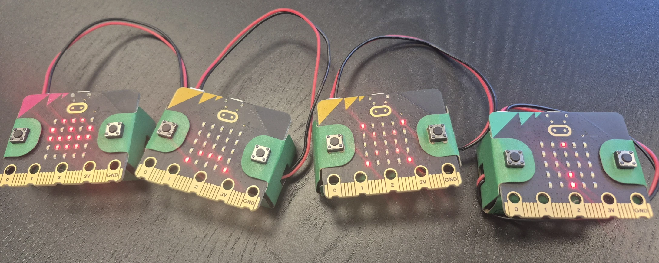 vier Microbits 4 Microbits liegen auf einem Tisch